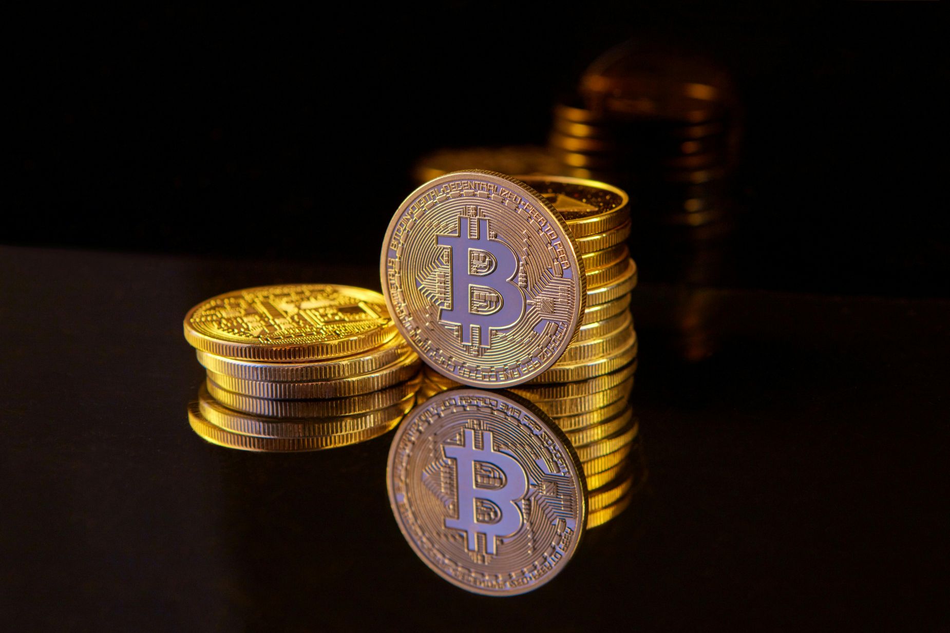 Bitcoin monetos sukrautos į krūveles, simbolizuojančios investavimą į kriptovaliutas ir kapitalo augimą.