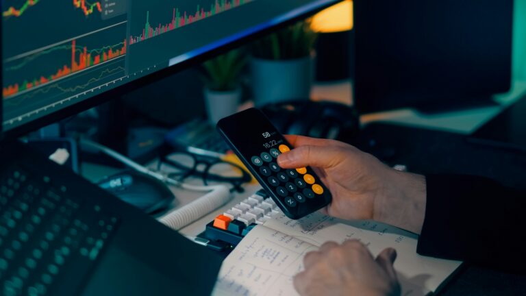 Investuotojas analizuoja rinkos grafikus ir skaičiuoja investicijų paskirstymą, simbolizuojantį „barbell“ portfelio strategijos planavimą.