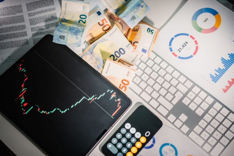 Investavimo aplinka su kainų grafikais, eurų banknotais ir analitiniais duomenimis, simbolizuojanti momentumo portfelio sudarymą pagal rinkos kainų tendencijas.